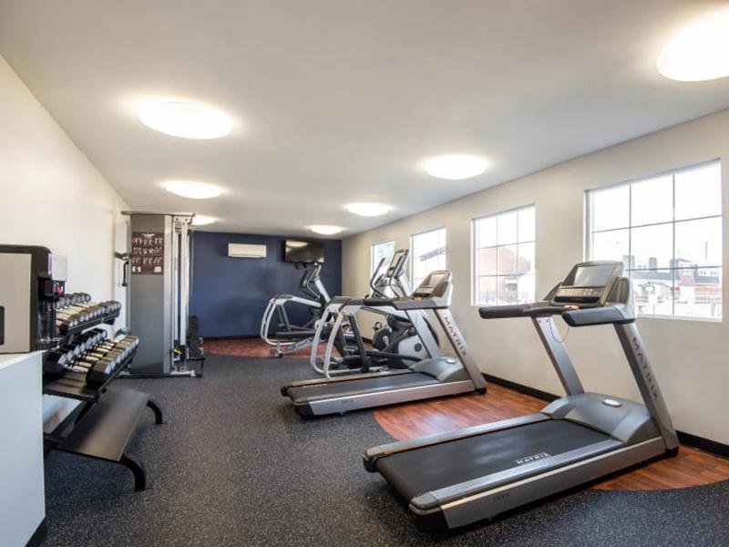 The community fitness center has cardio machines and free weights.