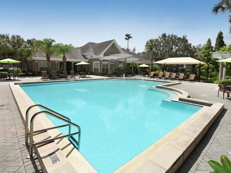The pool at Providence Lakes has a sun deck with lounge chairs and umbrellas