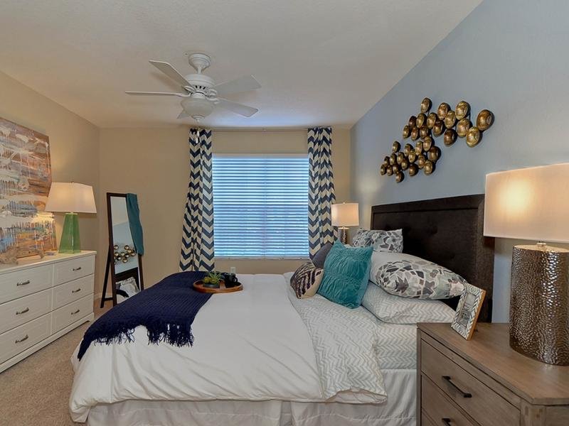 Large master bedroom with a bed, dresser and nightstands at Providence Lakes apartments