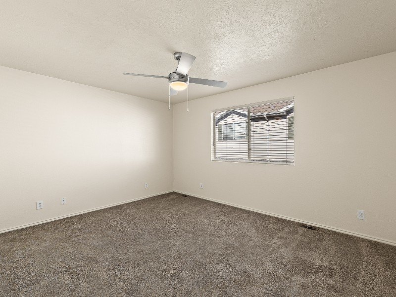 Carpeted Bedroom with Ceiling Fan | Sunridge Apartments